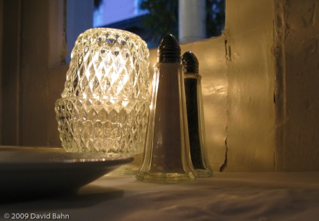 A candle, pepper and salt on the table in a Charleston, SC resaturant