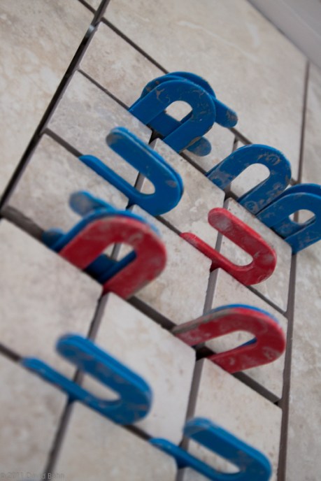 Spacers hold tiles in place in preparation for grout.