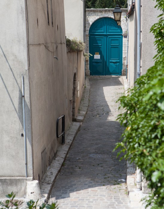 The small alleyway led to a beautiful teal-colored set of doors.