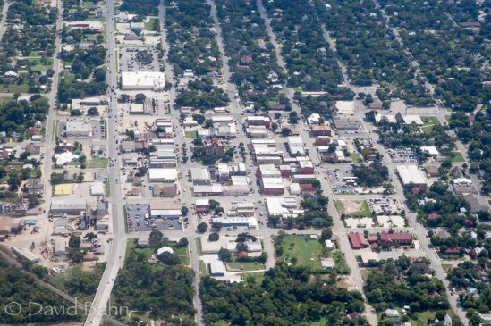 A church, town hall, and grocery store may be seen in this aerial photo of a small town Texas.